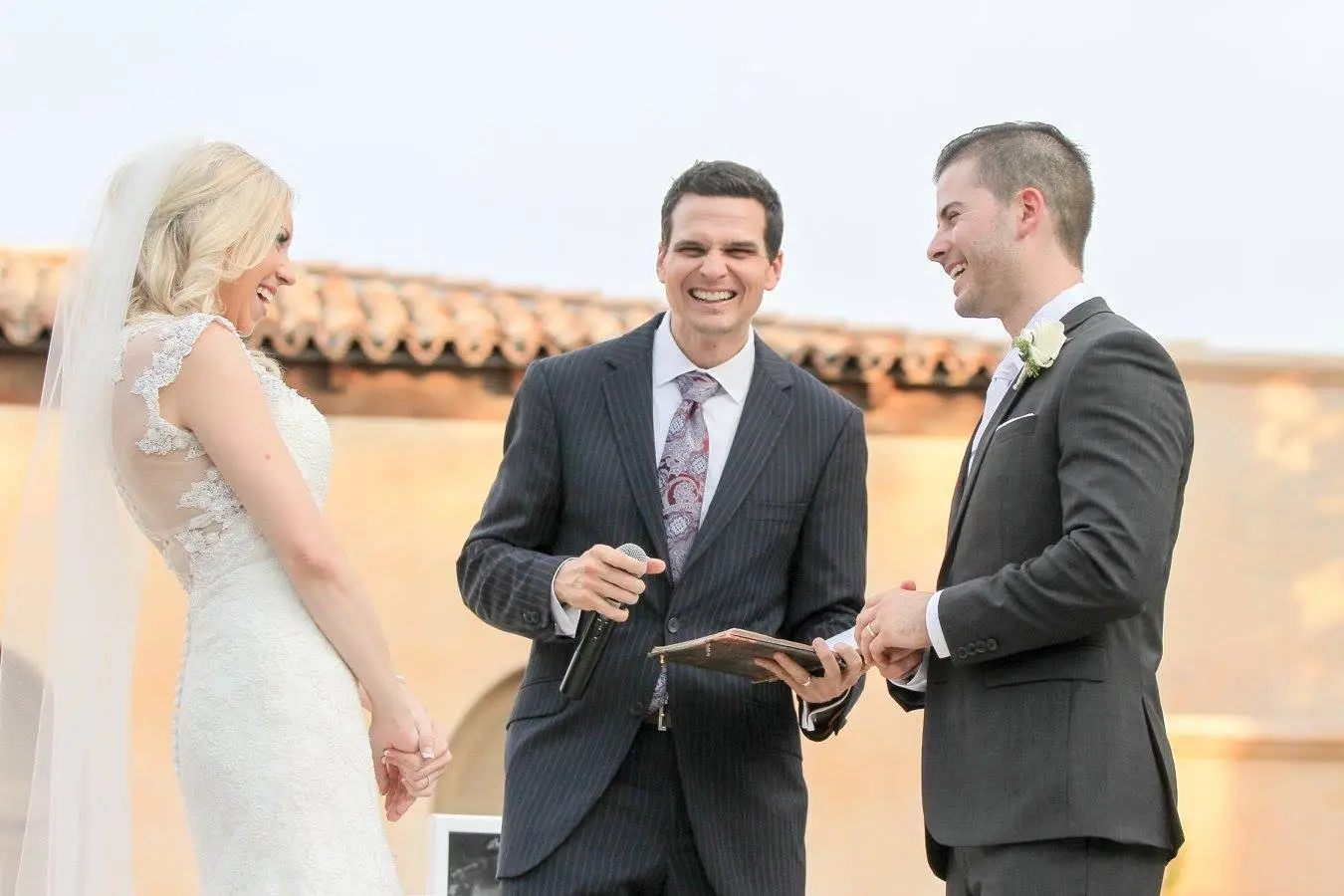 Minister laughing with a happy couple during a ceremony