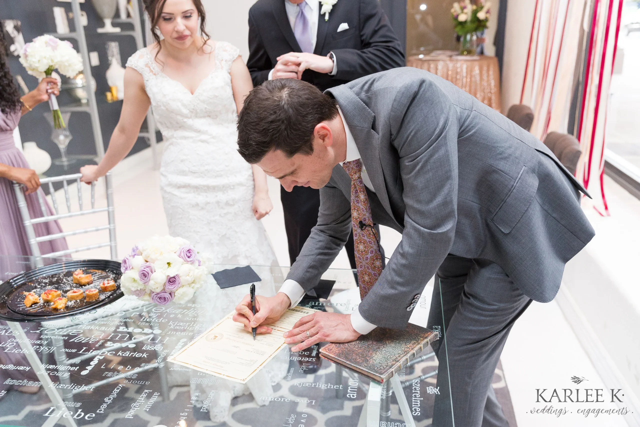 Officiant Matt Nathanson signing a marriage license with the couple